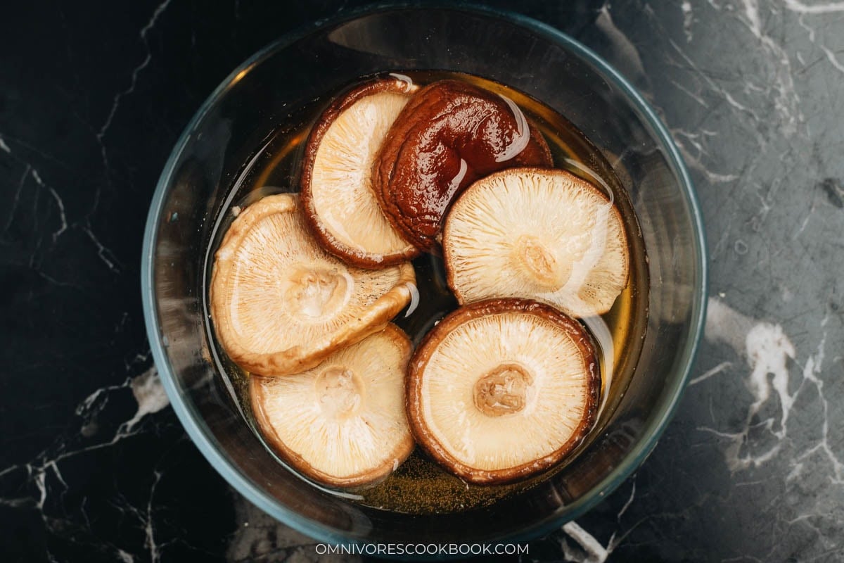 Dried shiitake mushrooms soaking in warm water to rehydrate