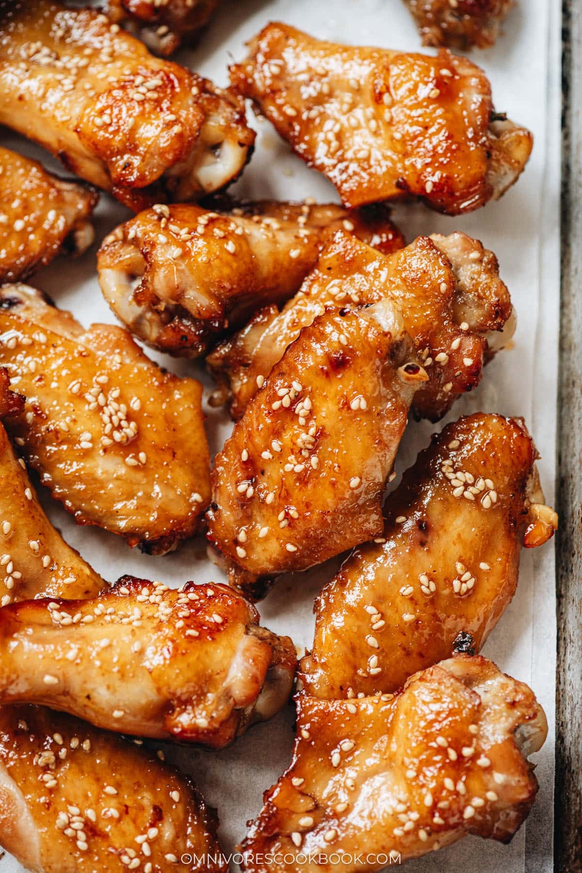 Baked Chimese honey soy chicken wings on parchment lined baking sheet