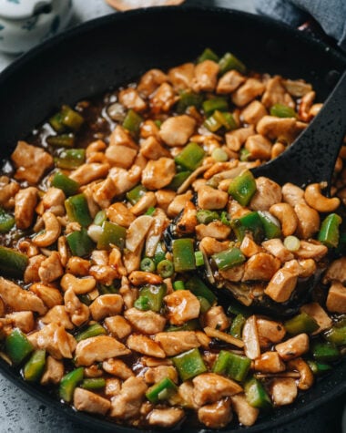 Delicious stir-fried chicken with green peppers in a black skillet.