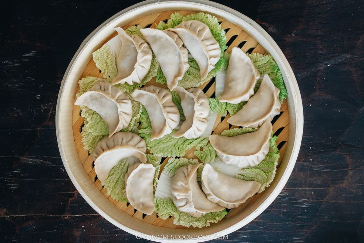 pork dumplings on napa cabbage in a steamer