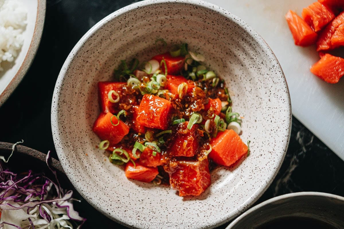Cubed salmon in a bowl with green onions