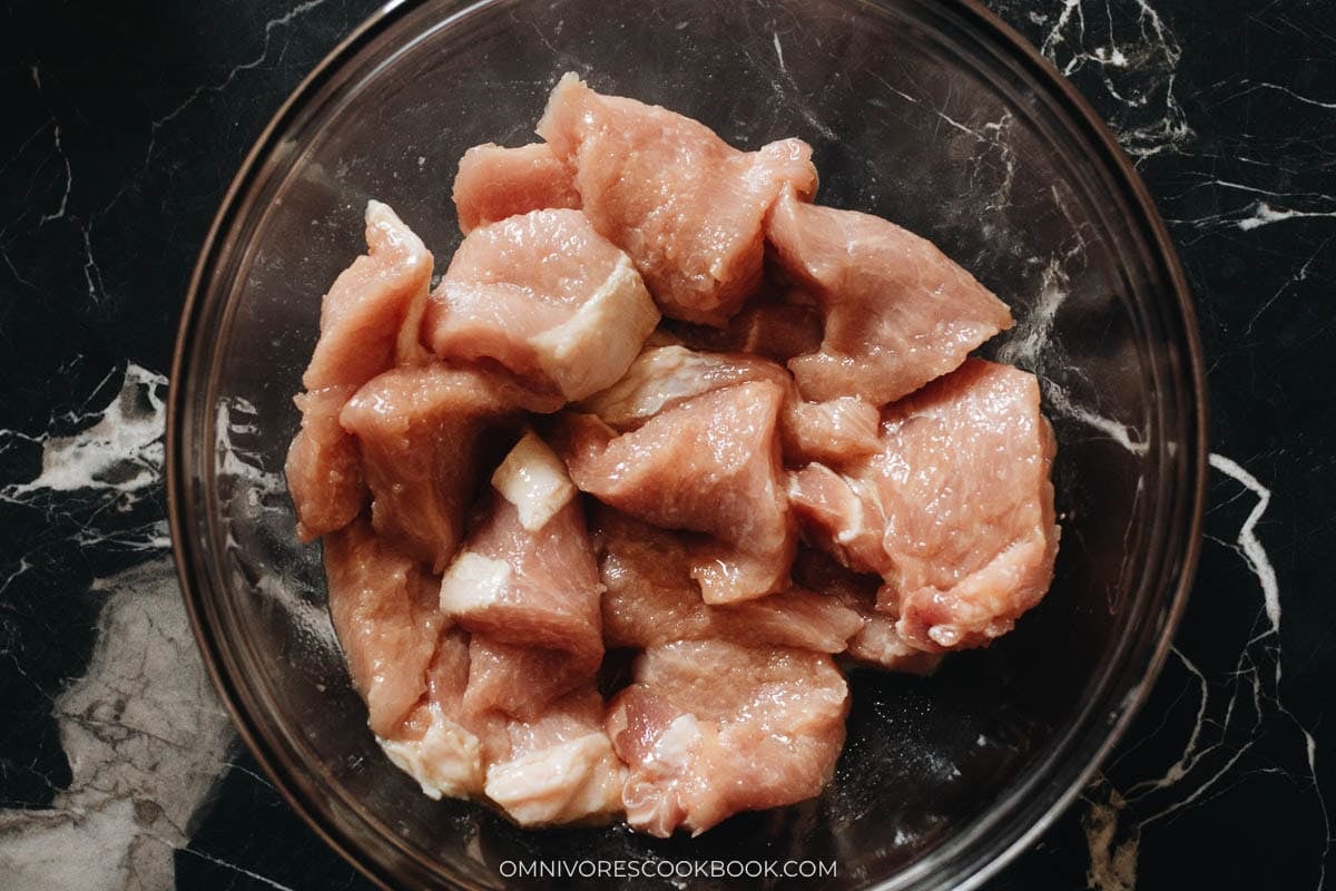 marinating the pork in a bowl