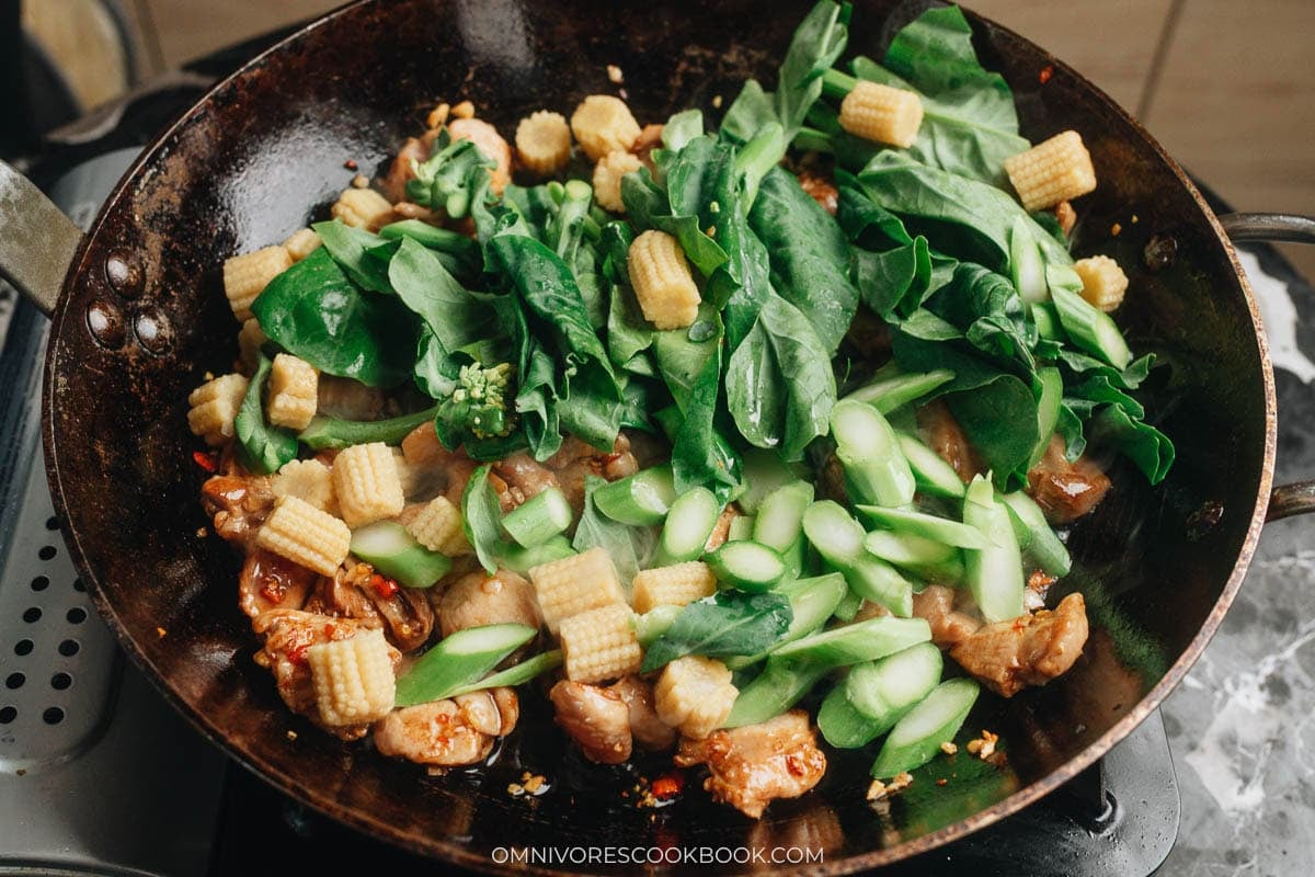 adding the vegetables to the pan and cook