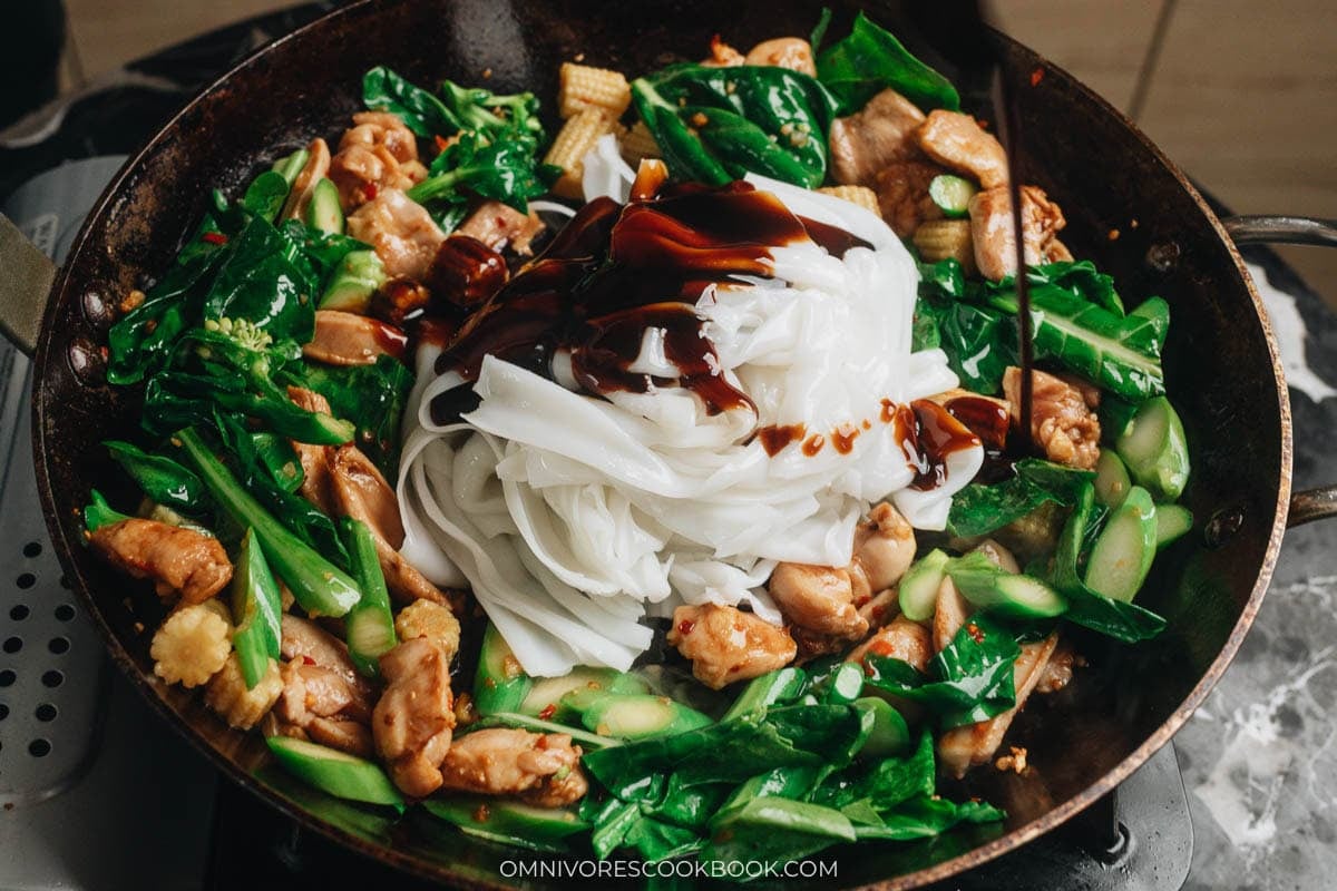 adding the noodles and sauce to the pan