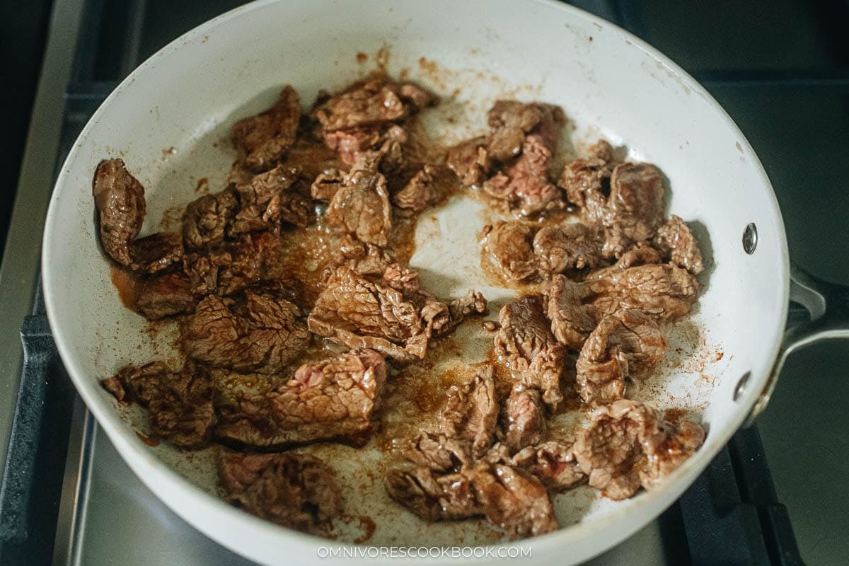 marinated beef cooking in a pan