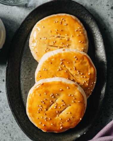 Wife&rsquo;s cake on a plate with golden flaky crust and sesame seeds