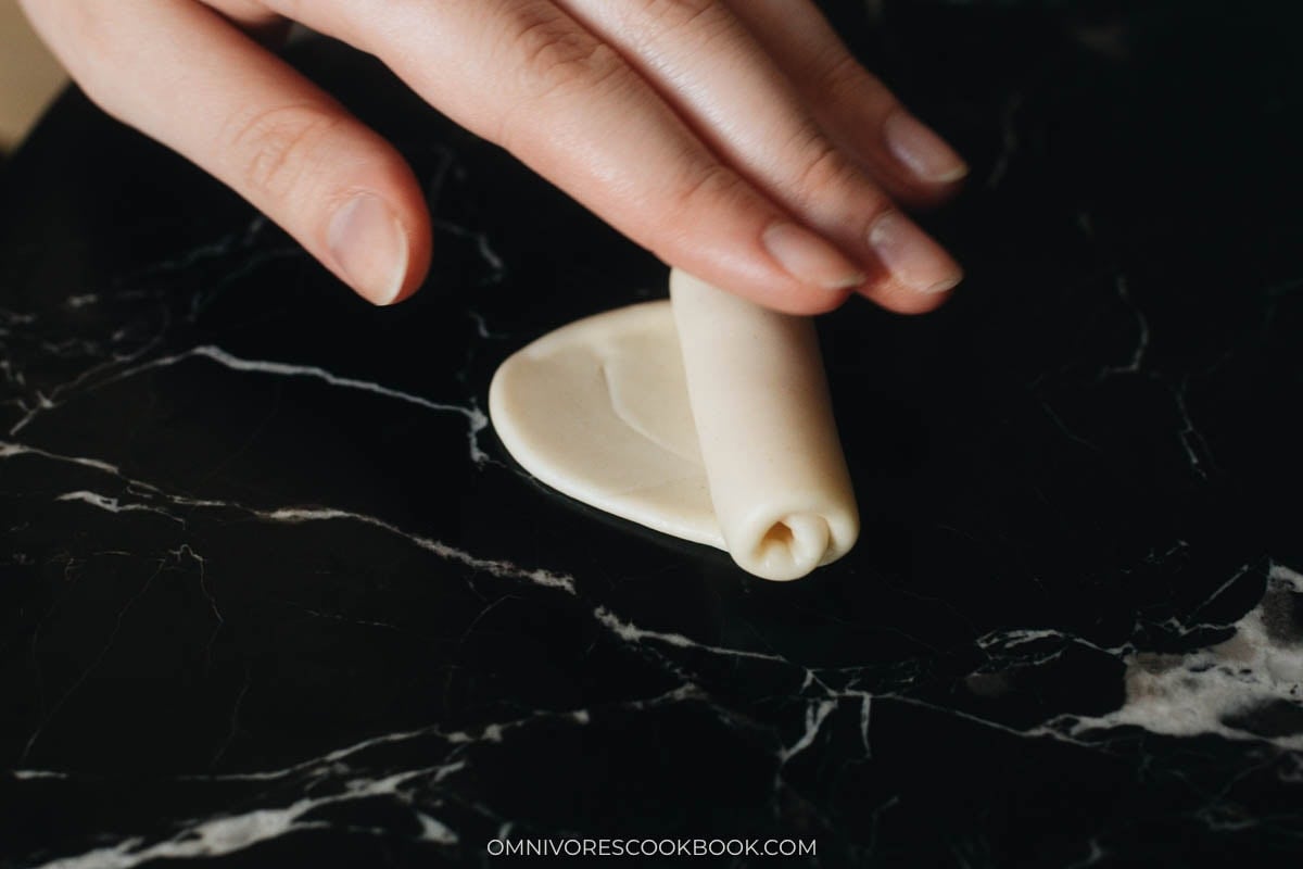 Rolling dough into a tight log to create laminated layers