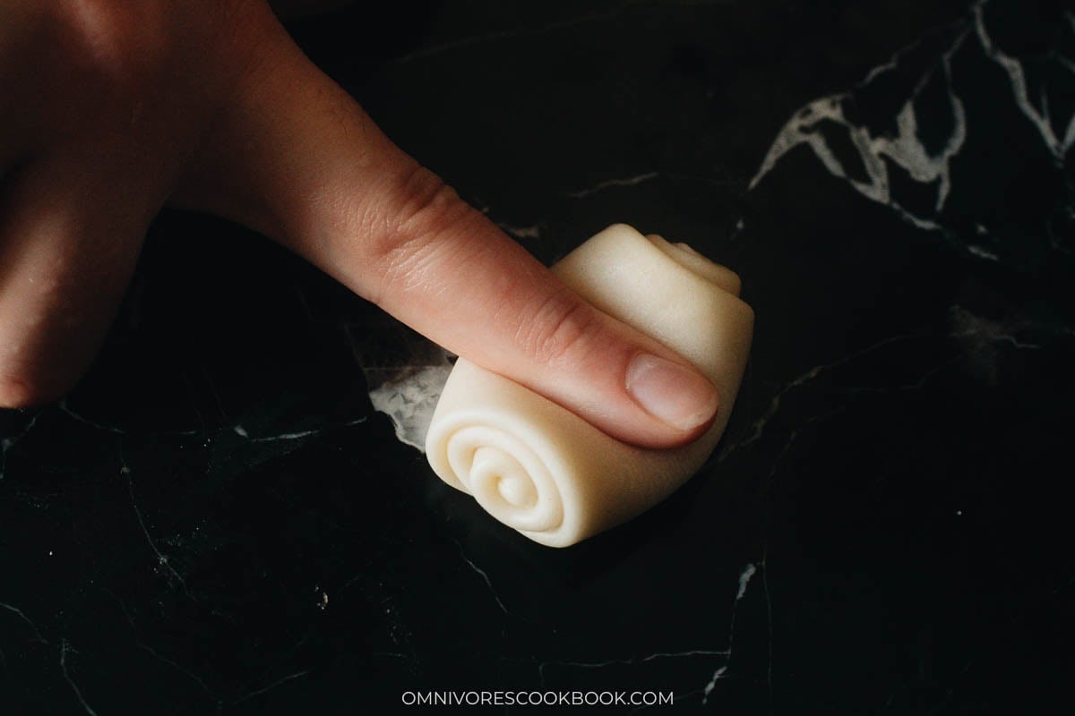 Using finger to press laminated dough coil