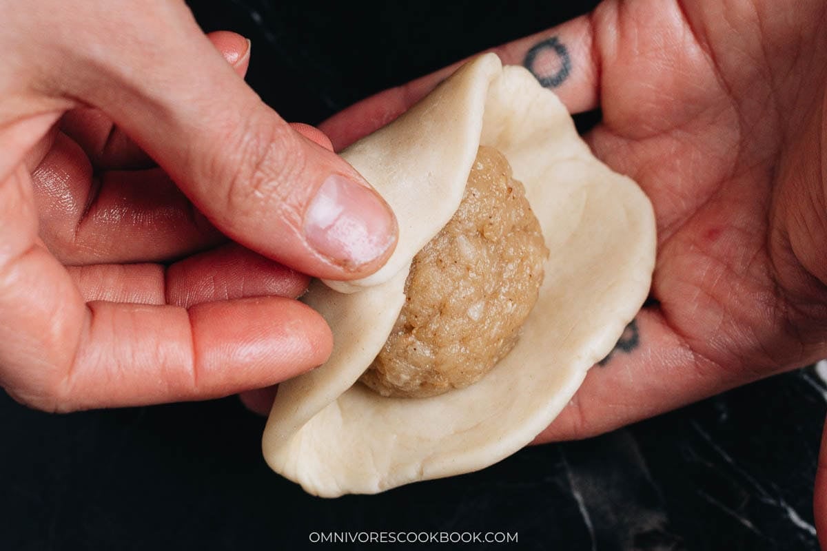 Wrapping filling with dough
