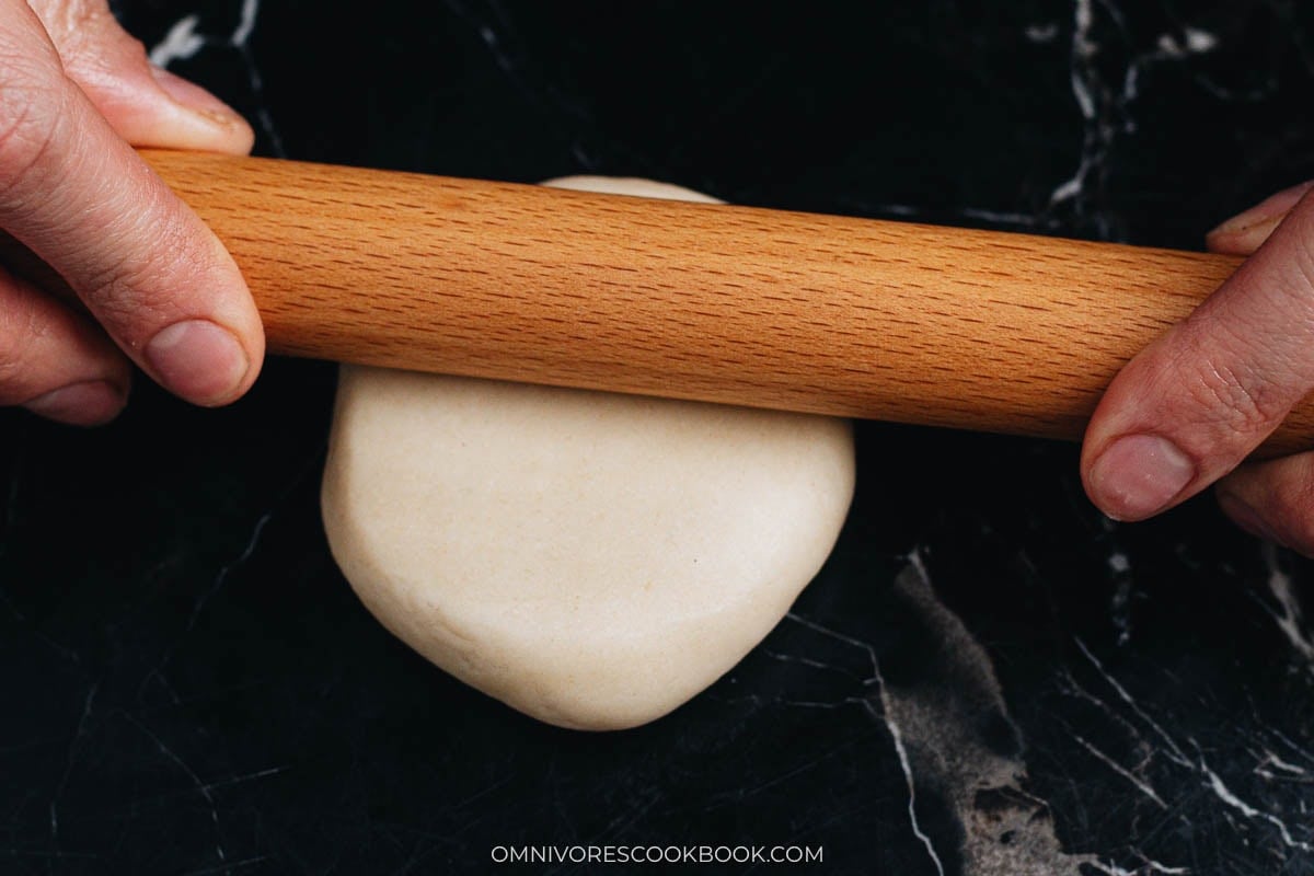 Rolling sealed dough into a smooth round disc for form wife&rsquo;s cake