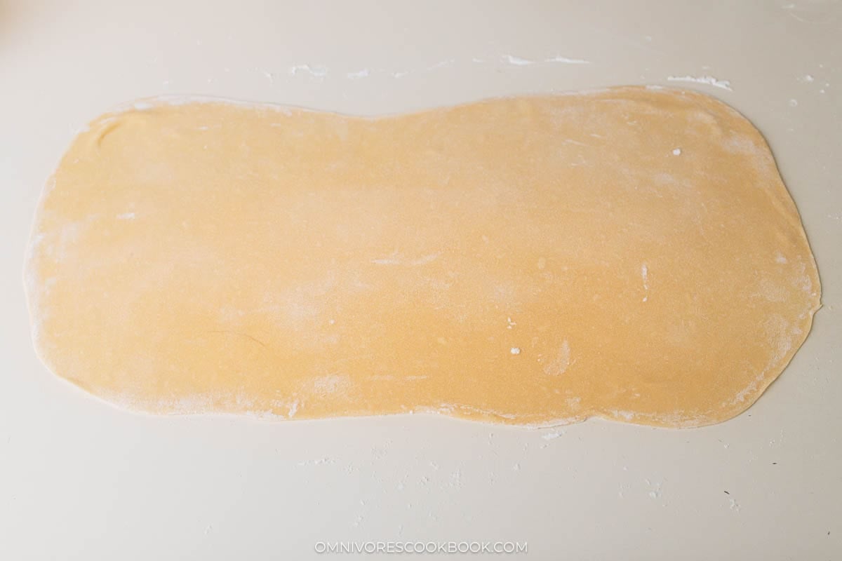 Roll the dough with a rolling pin to a large thin sheet.&nbsp;