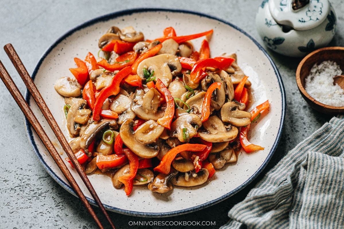 Stir fried white button mushrooms and red pepper in a plate