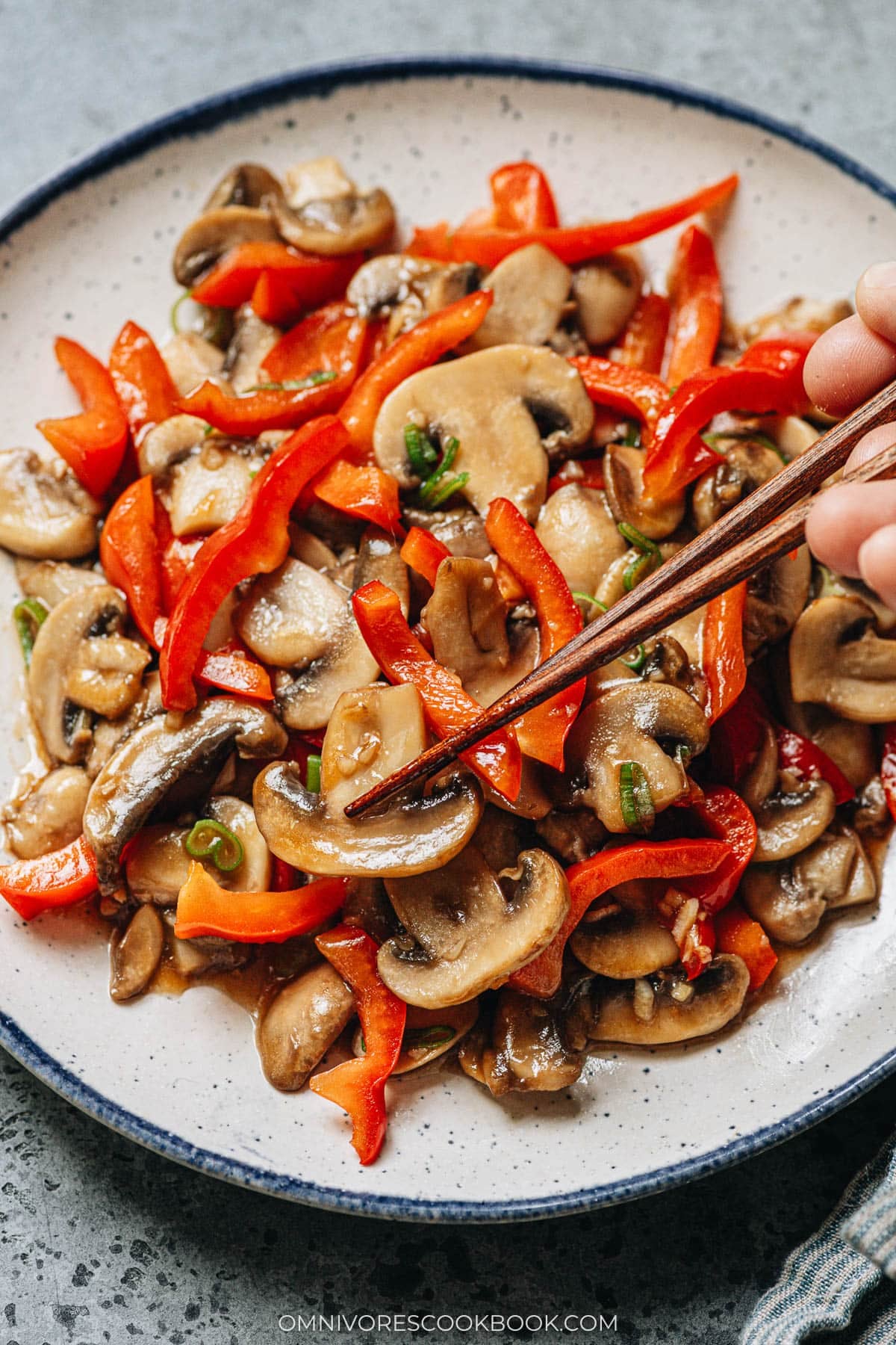 Use chopsticks to lift mushroom and pepper from a plate