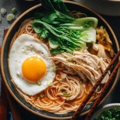 Korean noodle soup with chicken, egg and baby bok choy
