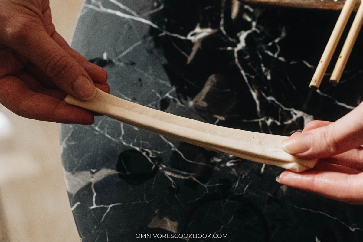Stretch the dough pieces into long strips