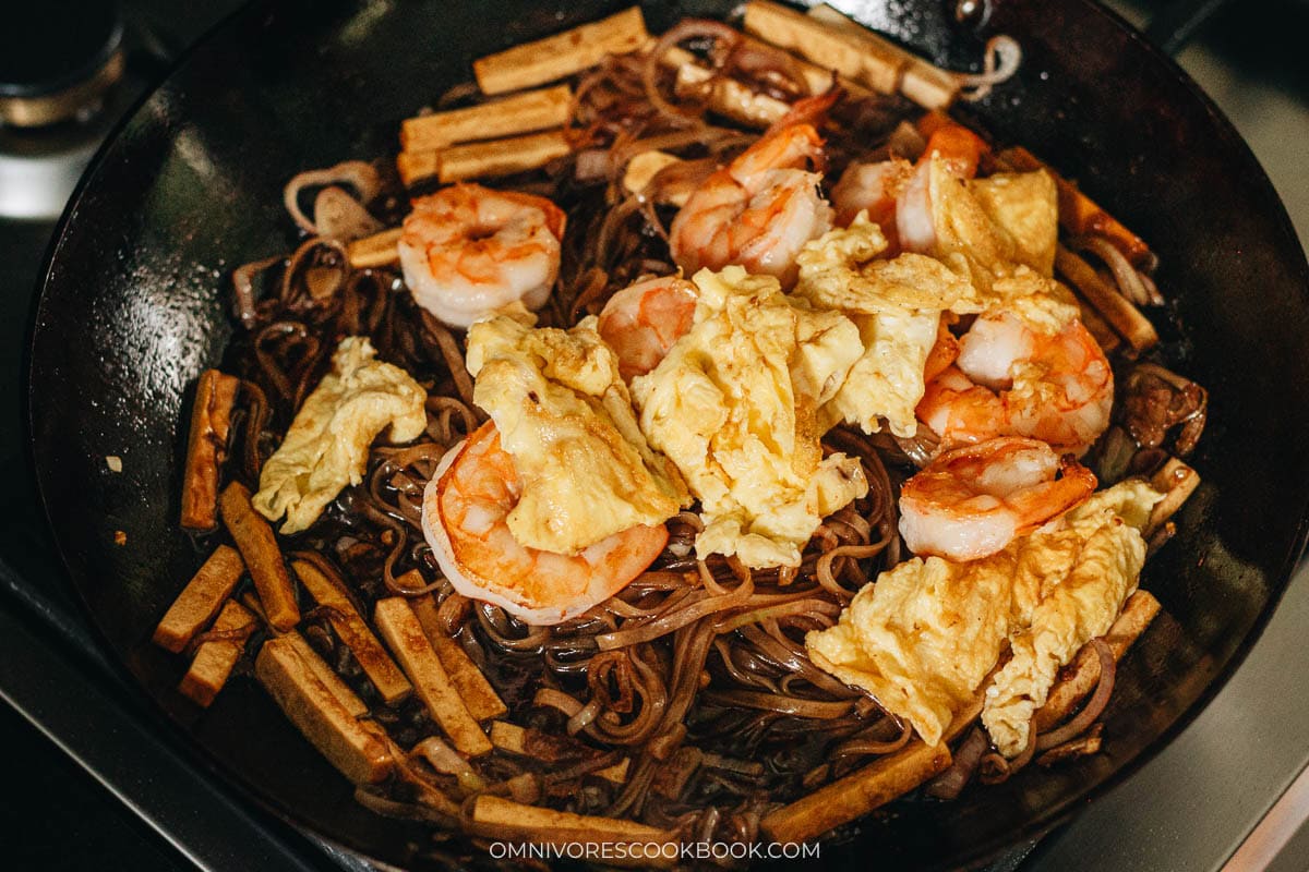 mixing in the tofu, shrimp, and egg