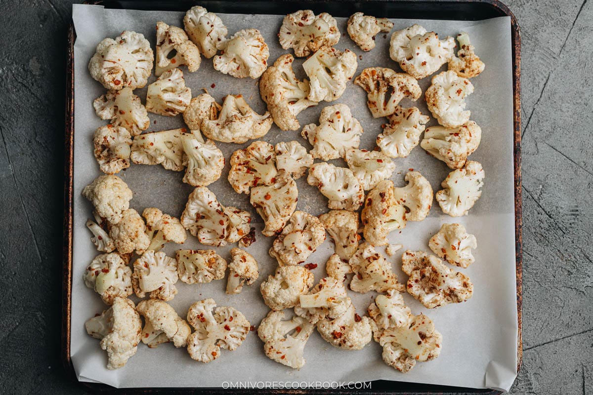 prepping the cauliflowers on parchment paper 