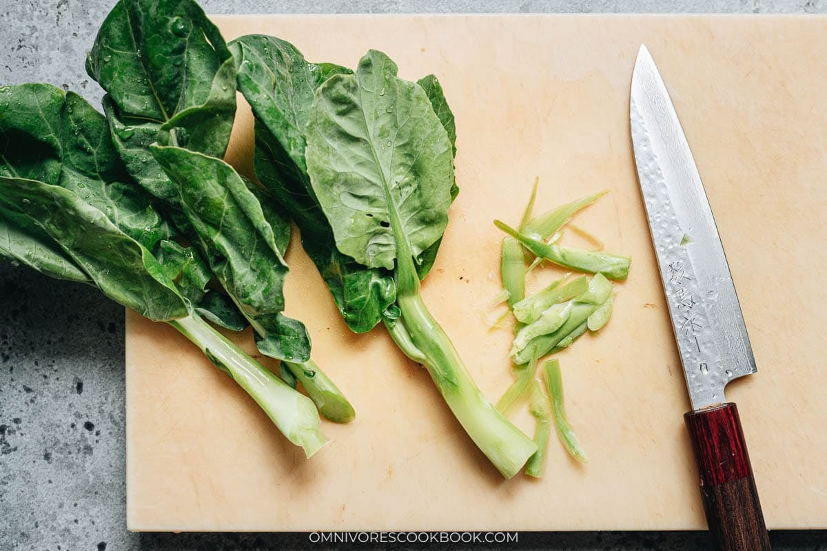 chinese broccoli sitting on cutting board