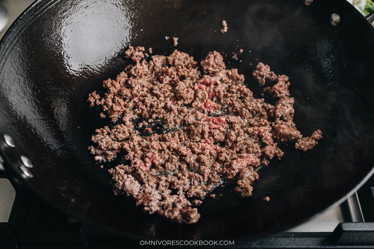 Ground beef browning in a wok