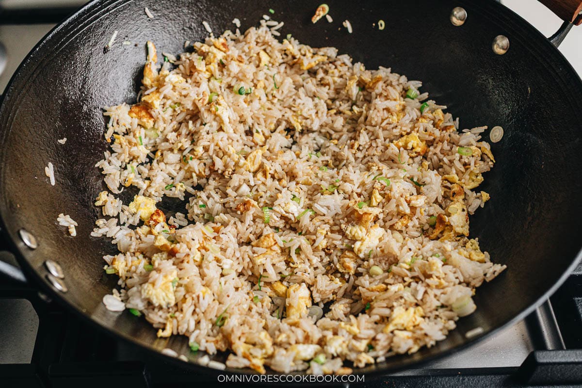 Rice and eggs stir-fried in a wok with soy sauce