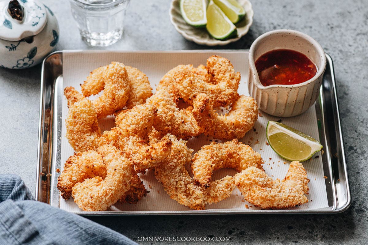 air fryer coconut shrimp plated with lime and sauce