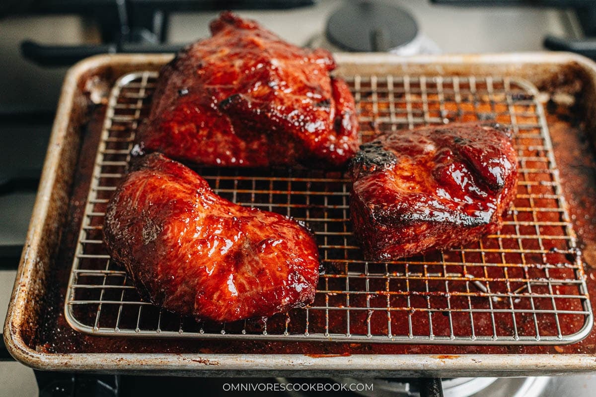 char siu resting on baking tray with a rack