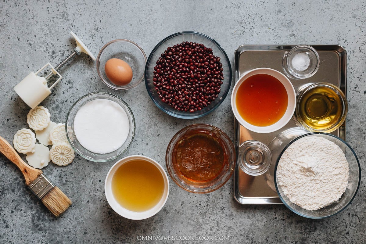 Assorted baking ingredients including eggs, flour, honey, and spices on a gray surface.