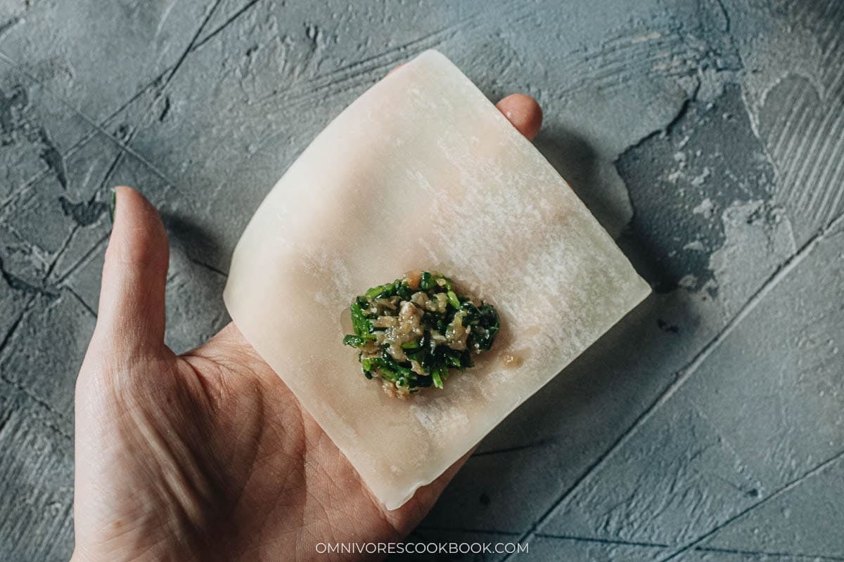 A spoonful of pork and watercress filling placed on a wonton wrapper