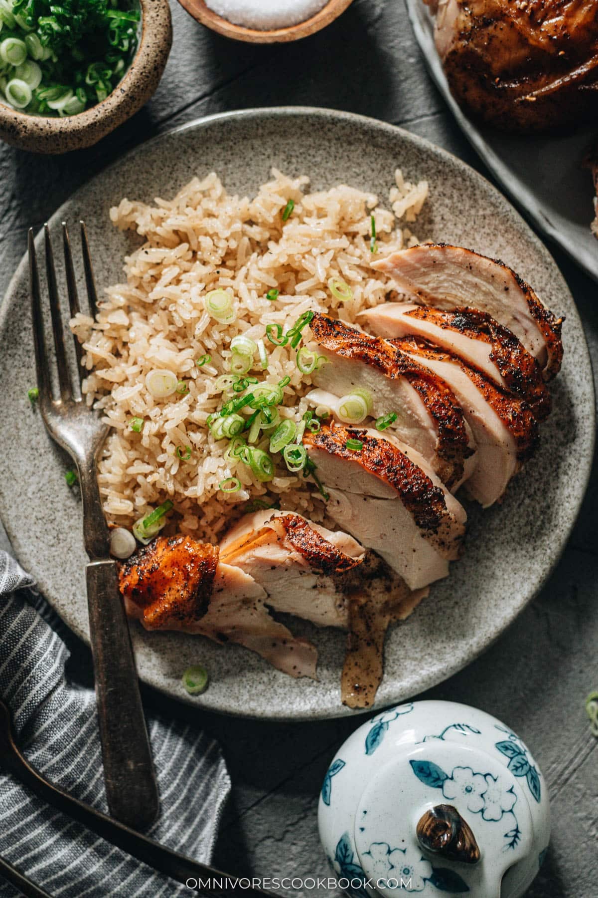 Sichuan roasted whole chicken with crispy skin, carved over ginger rice on a platter