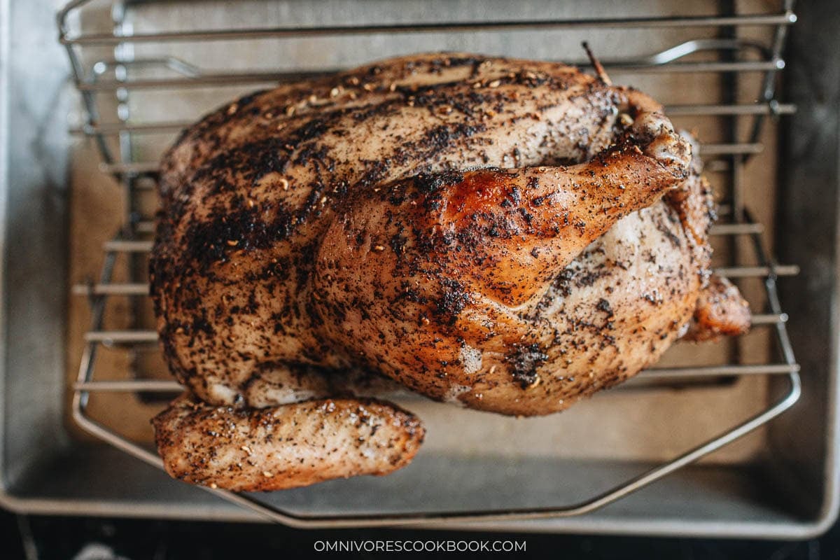 Sichuan roasted whole chicken resting on a rack
