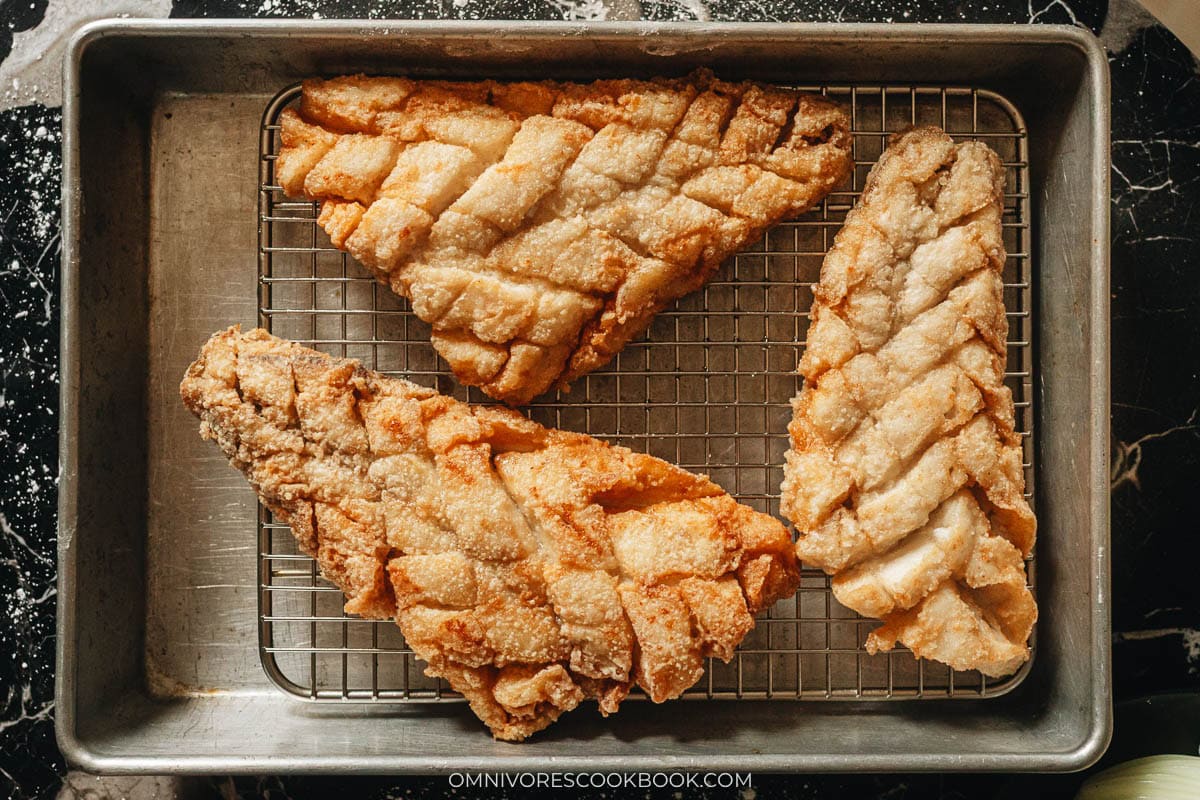 Fried fish fillets on a rack lined tray
