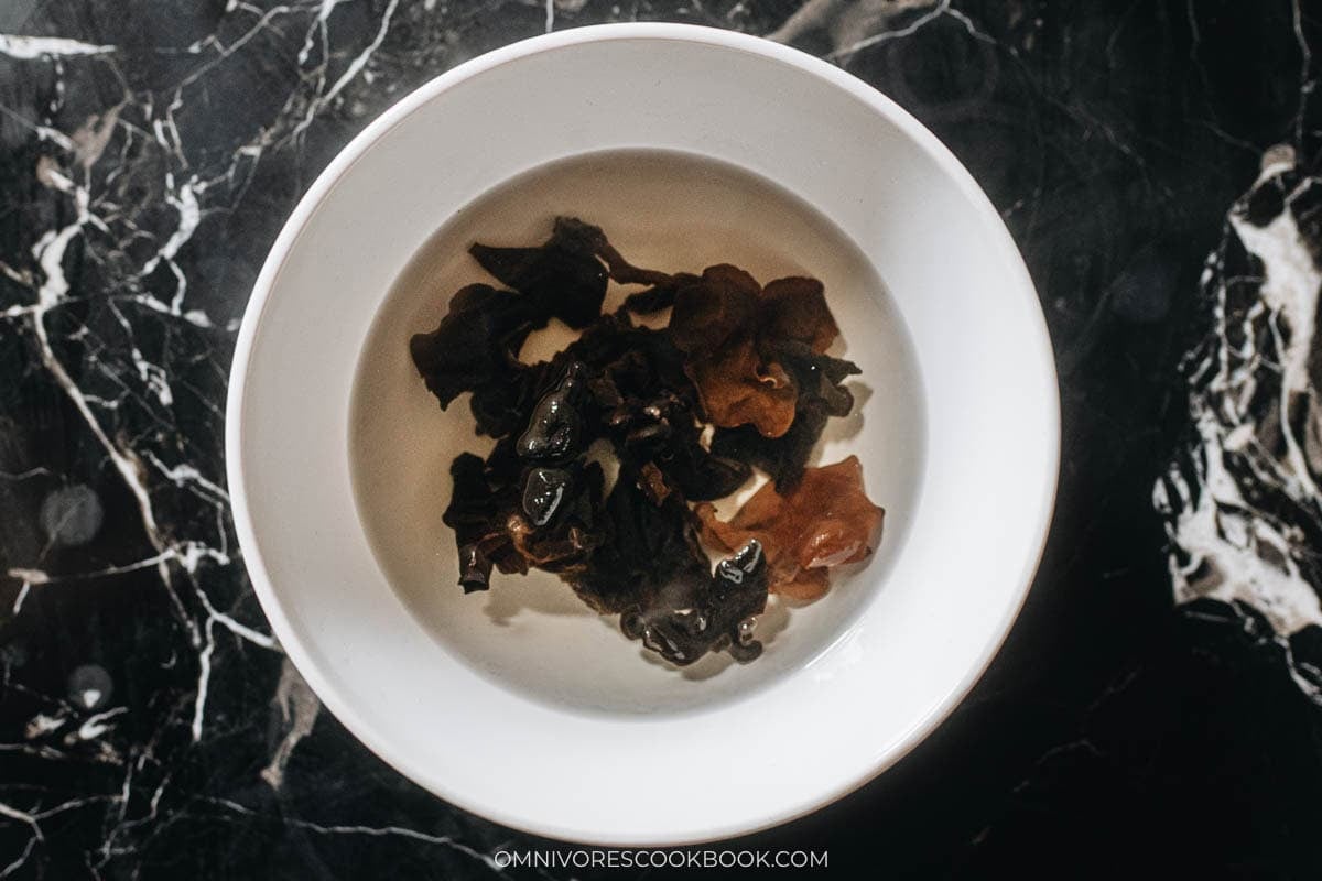 Dried wood ear mushrooms rehydrating in a bowl of hot water