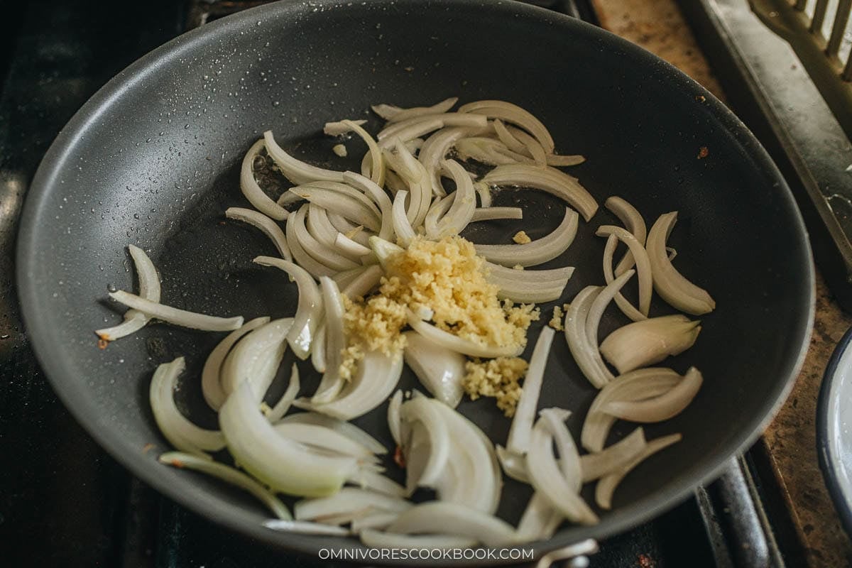 Sliced onion browning in the pan with minced ginger