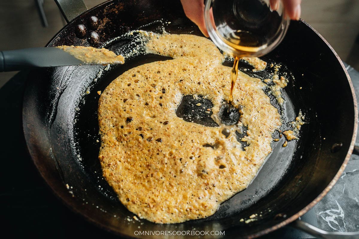 Shaoxing wine deglazing the salted egg yolk coating in the skillet