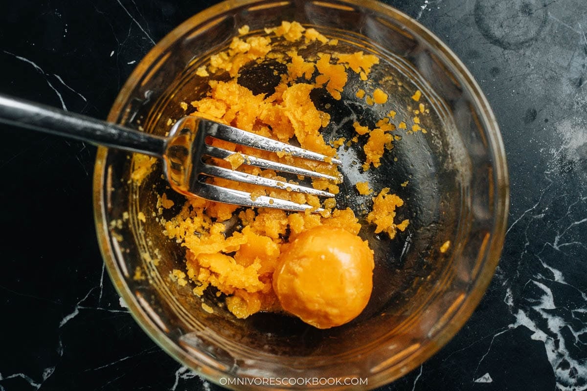 Cooked salted duck egg yolks crushed fine with a fork in a small bowl