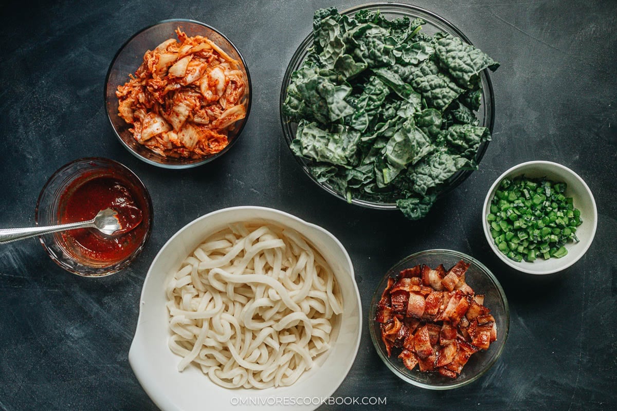 Bacon kimchi fried udon ingredients including udon, kimchi, kale, gochujang, and bacon
