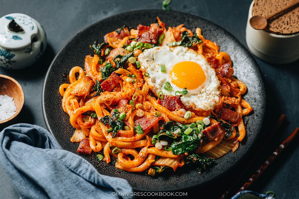 Udon noodles tossed with kimchi, bacon, and gochujang sauce in the skillet