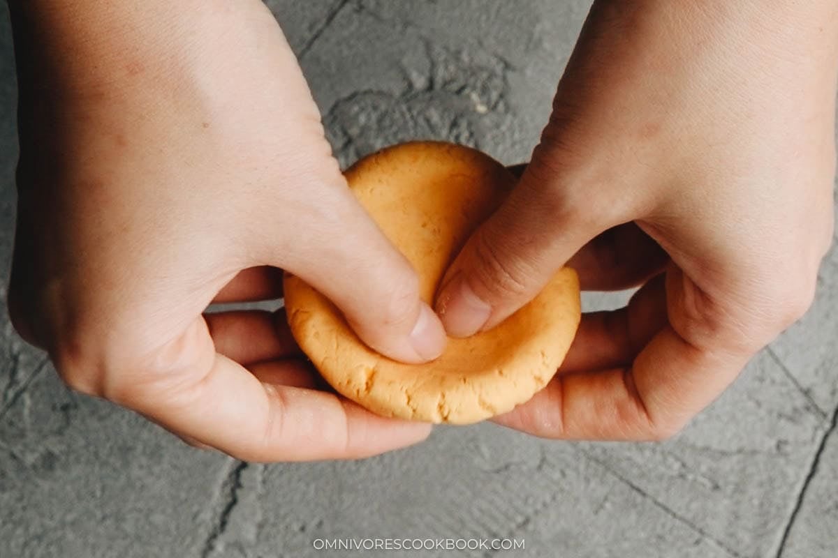 Dividing the pumpkin cake dough into equal pieces and rolling them into balls