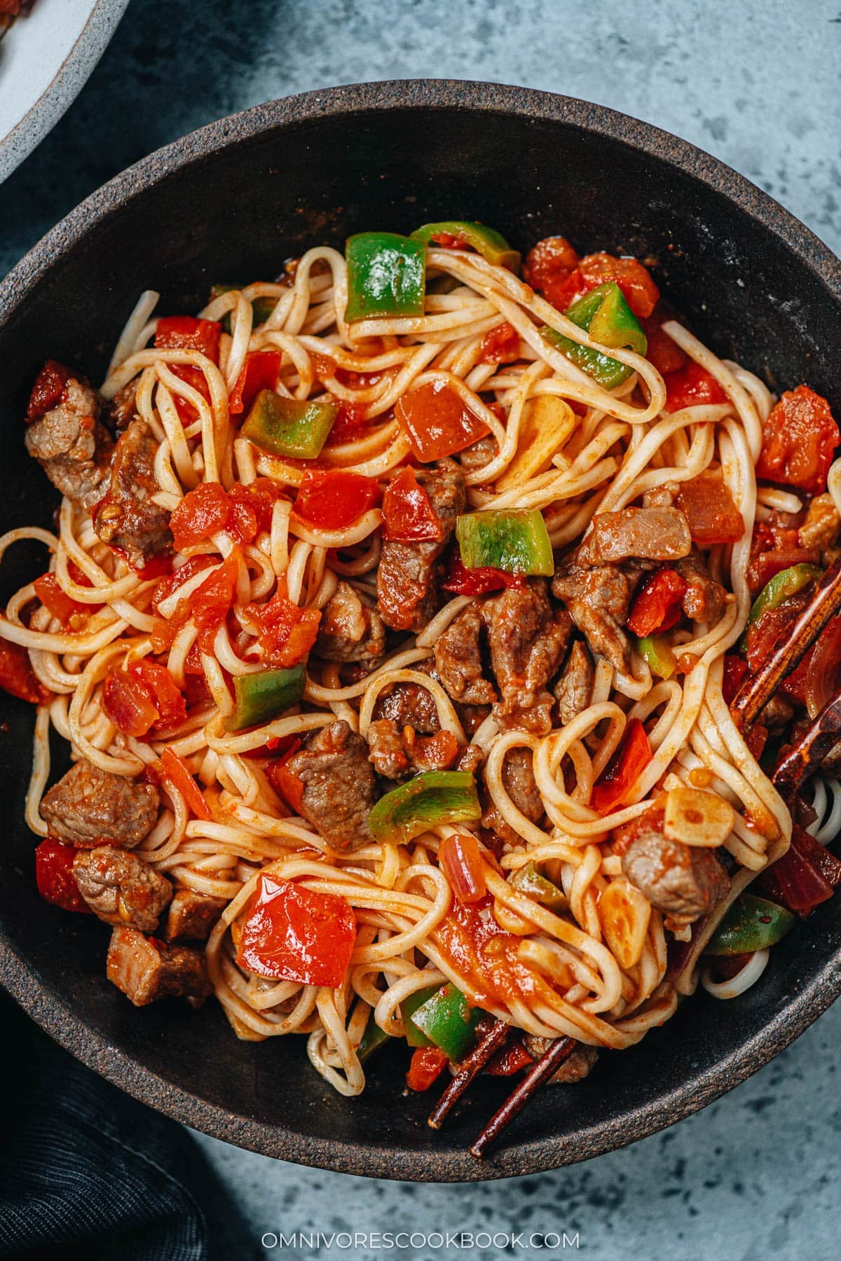 Lamb sauce spooned over noodles for Uyghur style noodles with lamb sauce