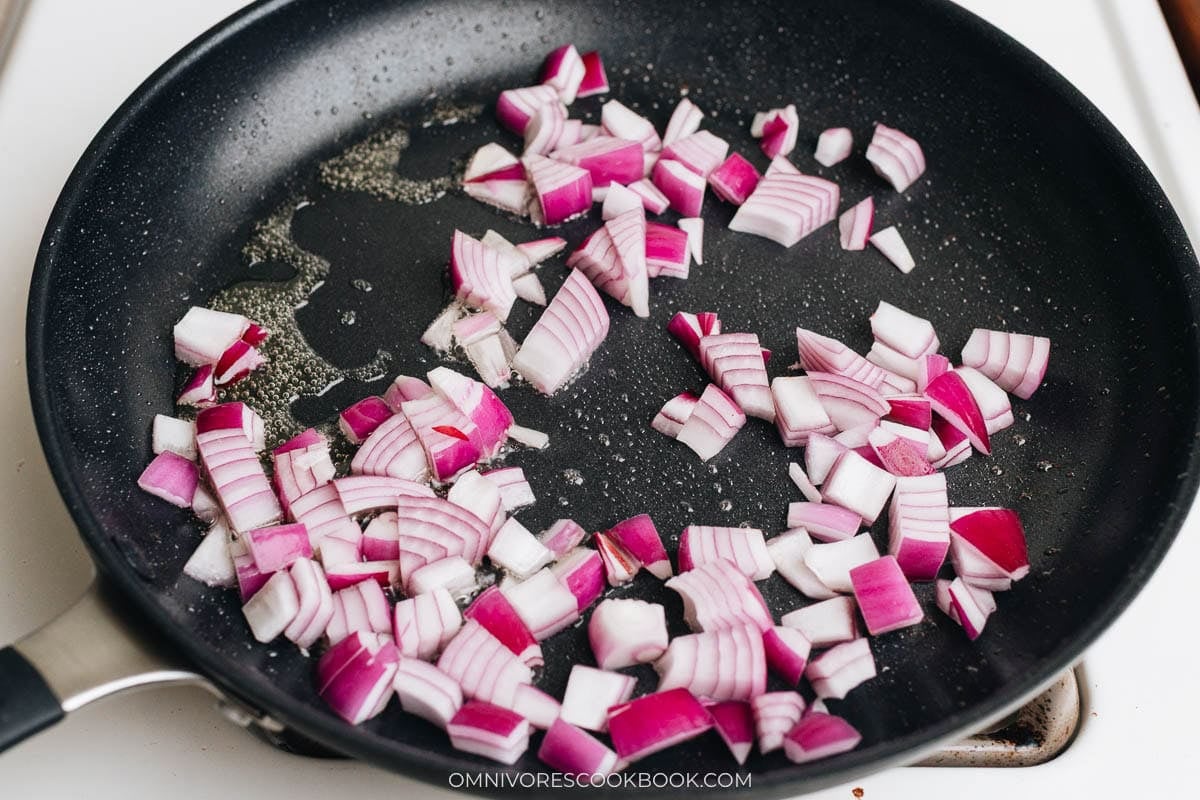 Diced purple onion softening in the skillet