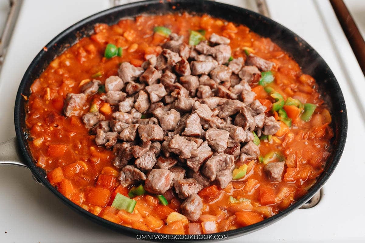 Browned lamb returned to the tomato sauce in the skillet