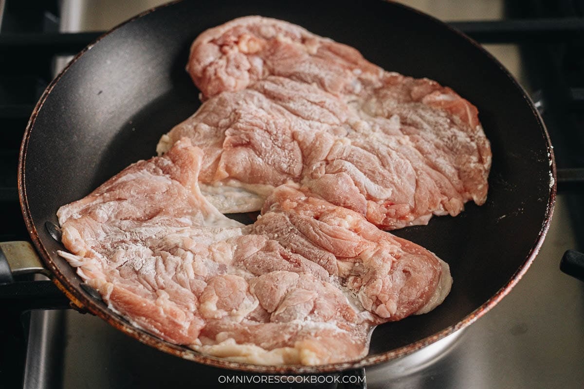 Teriyaki chicken cooking skin side down in a cold pan
