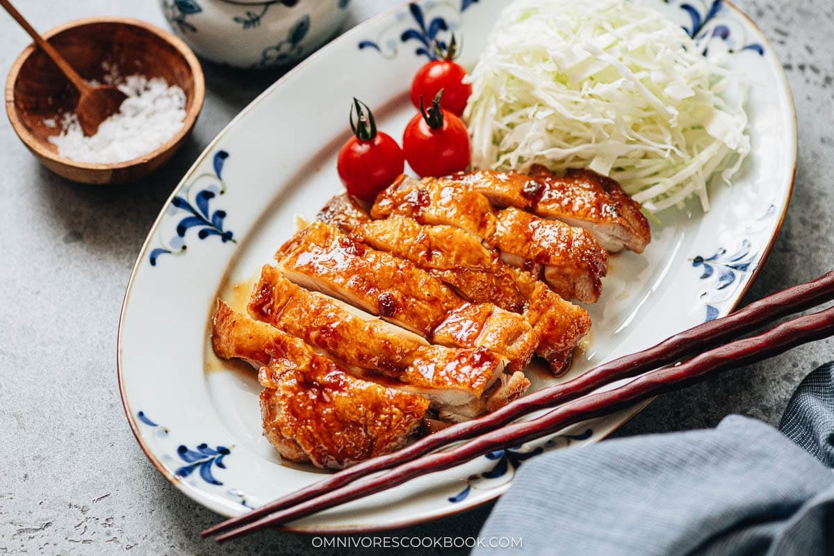  Finished teriyaki chicken on a plate with the glossy sauce poured over the skin
