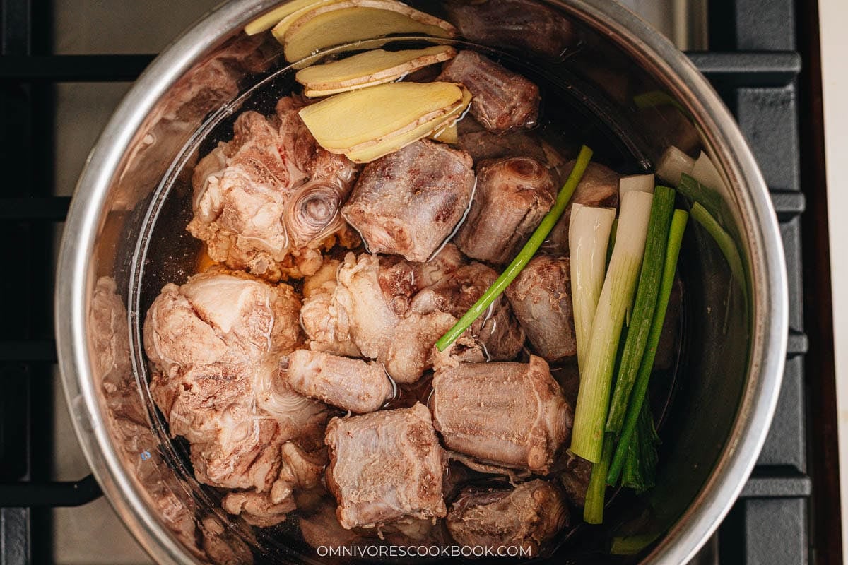 Oxtail pieces pressure cooking with ginger and green onion in the Instant Pot