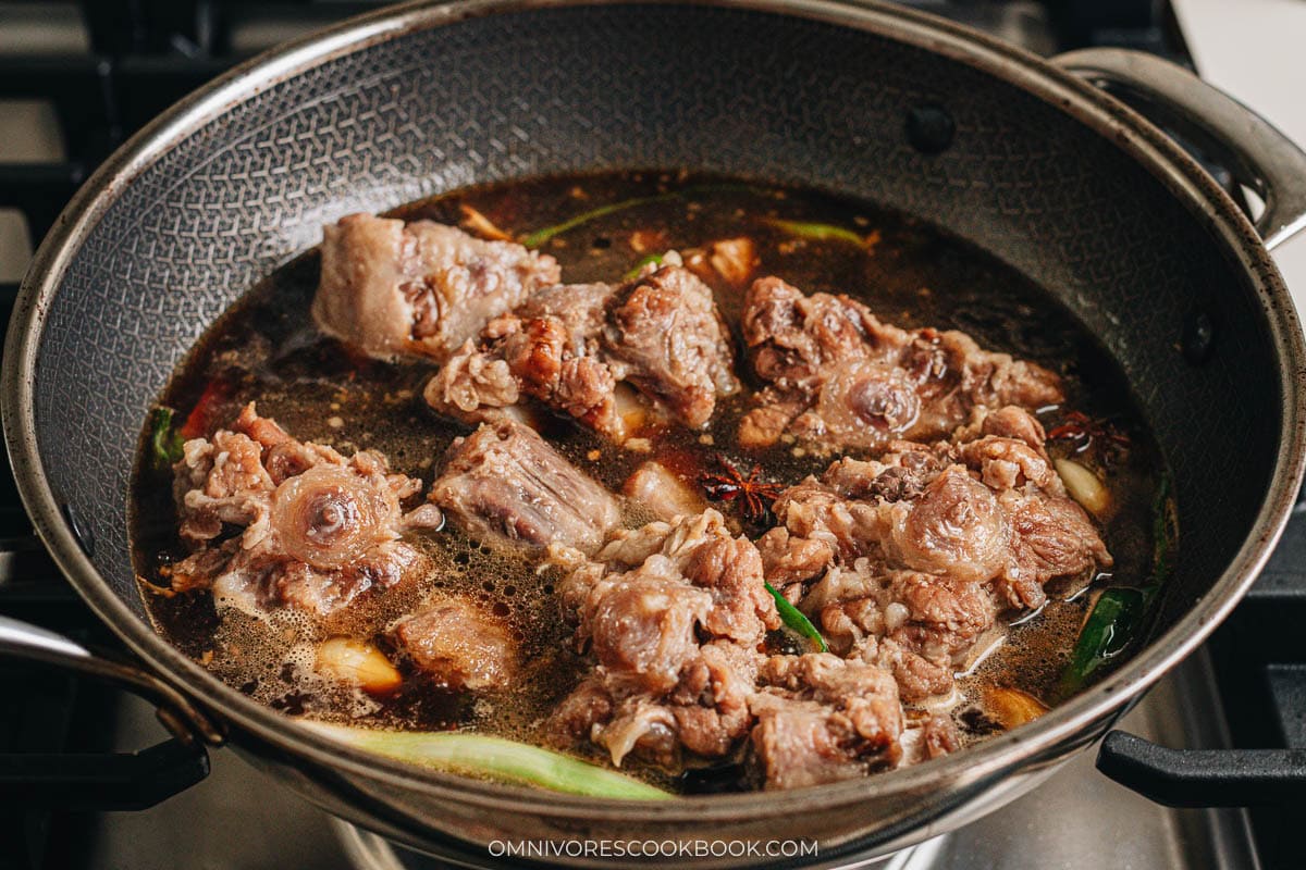Oxtail tossed with soy sauce and the reserved broth in the wok