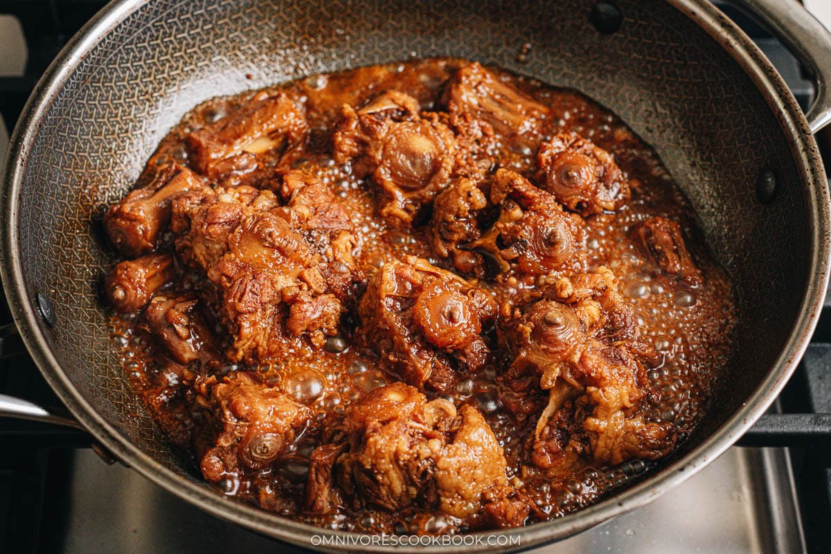 Glossy reduced sauce coating the braised oxtail in the wok