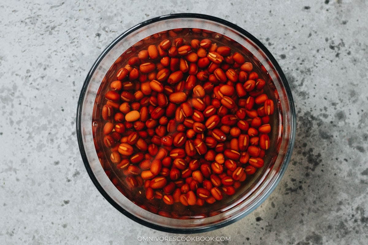 Rinsed azuki beans soaking overnight in a bowl of water
