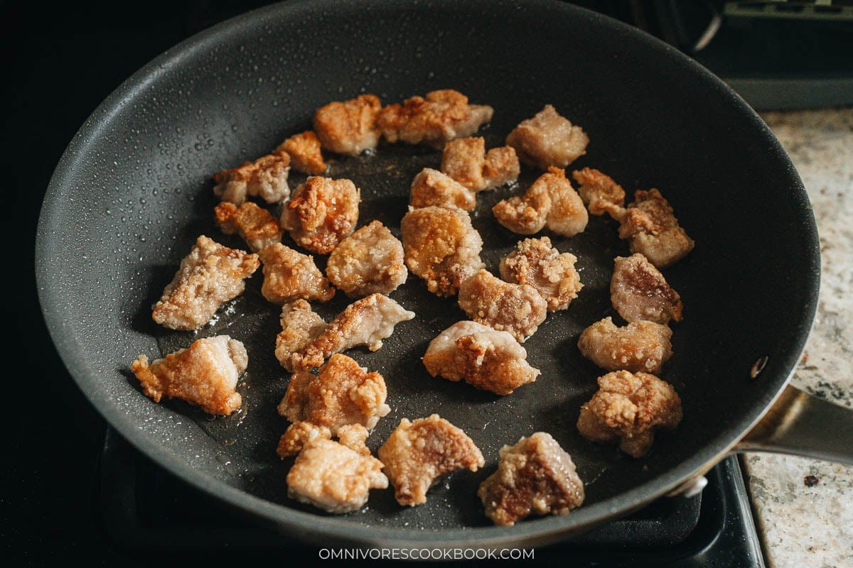  Popcorn chicken frying golden brown in a single layer in a nonstick skillet
