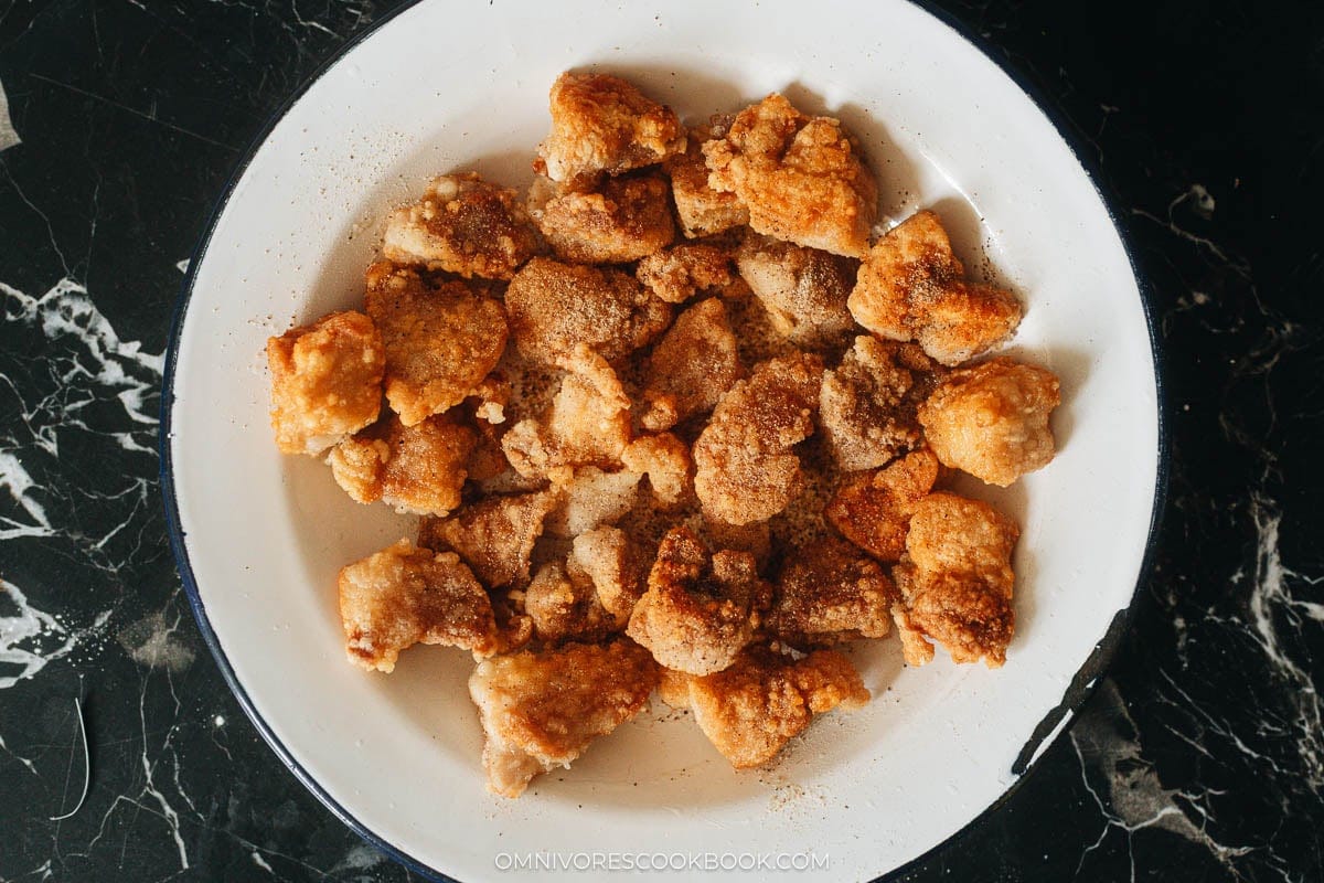 Fried popcorn chicken tossed with white pepper on a plate
