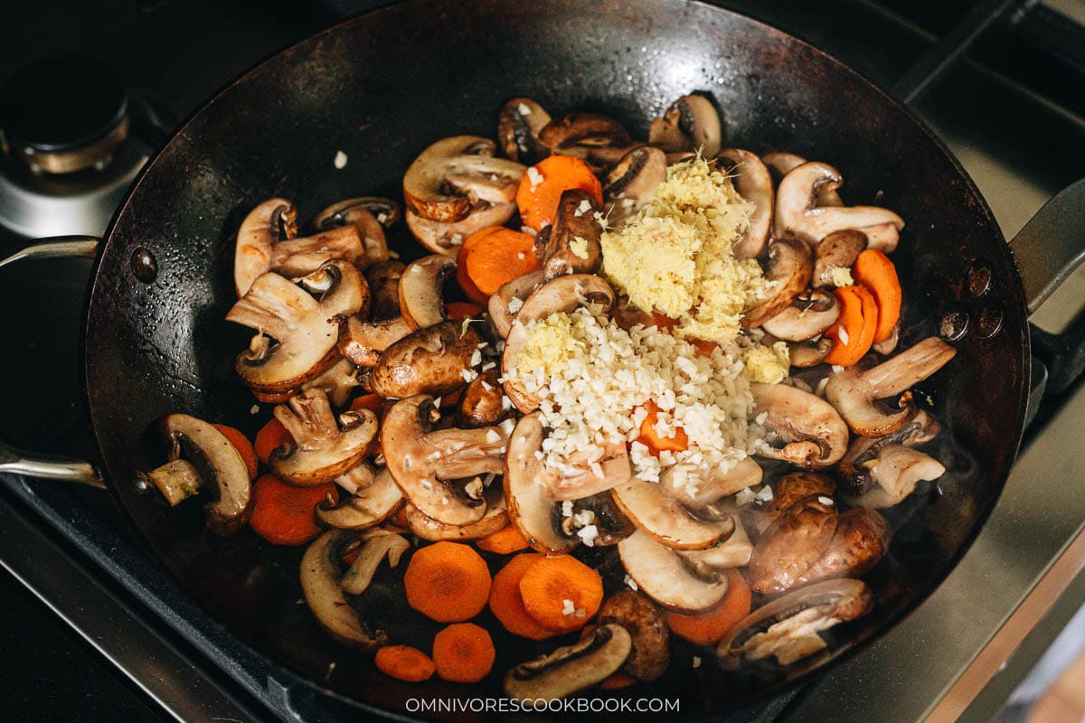 Minced garlic and grated ginger cooking with the vegetables